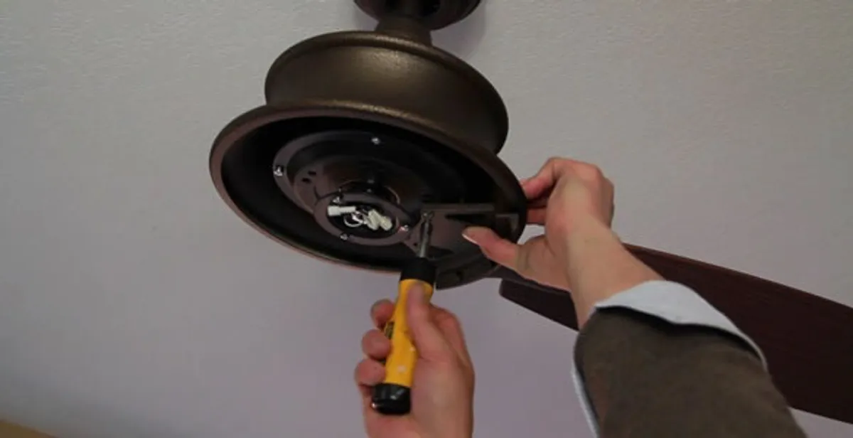 Electrician installing ceiling fan mounting bracket and fixture in Peoria, IL