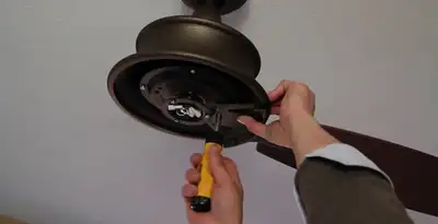 Electrician installing ceiling fan mounting bracket and fixture in Peoria, IL