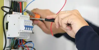 Electrician installing and adjusting circuit breakers in an electrical panel in Peoria, IL
