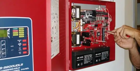 fire alarm installation service showing technician configuring fire alarm control panel in Peoria, IL