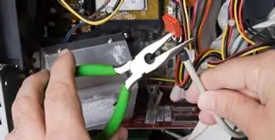 Licensed electrical contractor performing electrical repair with tools in Groveland, IL