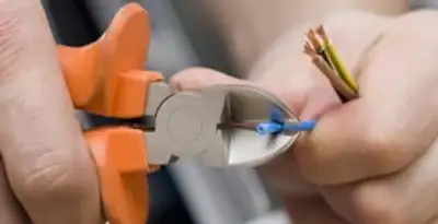 professional electrical services showing precise wire cutting by licensed electricians in Peoria, IL