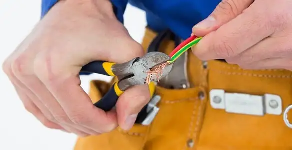 licensed electrician securing electrical wiring with professional tools during service work in Peoria, IL