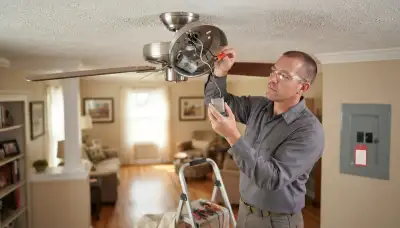 Electrician replacing a ceiling fan capacitor and securing wire connectors in a Peoria, IL home