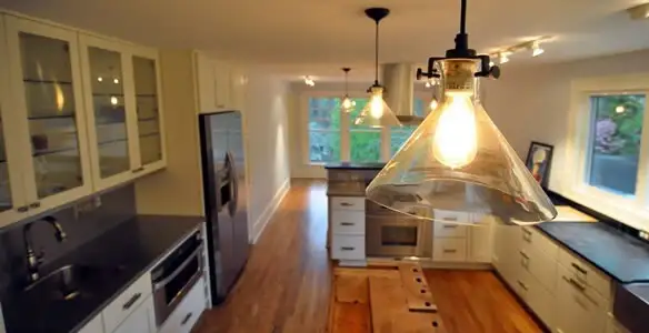 Residential electrician installing modern indoor light fixture in a home in Peoria, IL